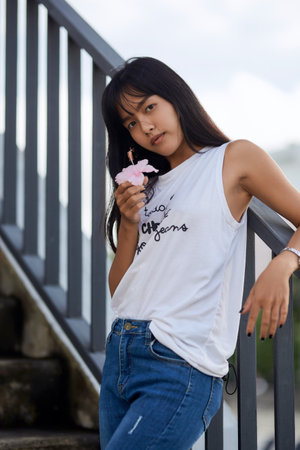 Outdoor close-Up fashion portrait of young Asian woman posing on stairs