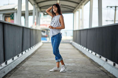 Outdoor fashion portrait of young Asian woman posing in the corridorの写真素材