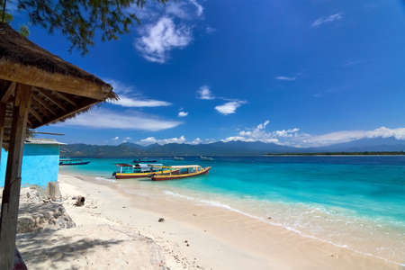 Traditional wooden boat on beautiful tropical beach at sunny morningの写真素材