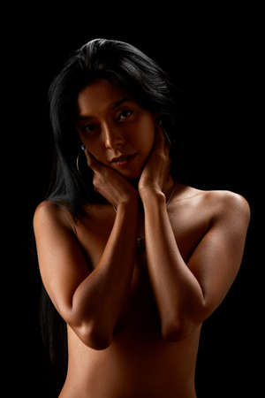 Close-Up portrait of young asian nude sexy girl posing in studio on the black background. Low keyの写真素材