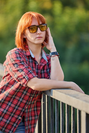 A redhead woman poses gracefully in the warm glow of an autumn sunsetの写真素材