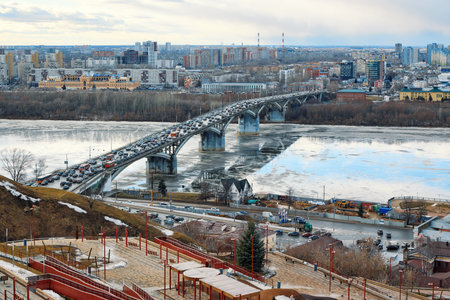 Traffic congestion on Kanavinsky Bridge in Nizhny Novgorod during a crisp winter morning, icy river below reflecting the bridgeの写真素材