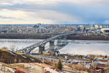 Traffic congestion on Kanavinsky Bridge in Nizhny Novgorod during a crisp winter morning, icy river below reflecting the bridgeの写真素材