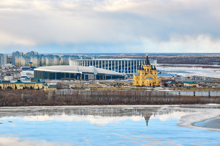 Alexander Nevsky Cathedral and Nizhny Novgorod Stadium on a serene winter morning, ice-covered river reflecting the stunning architecture, blending history and modernityの写真素材