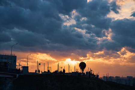Silhouette of a monument featuring a hot air balloon set against a breathtaking sunset, vibrant clouds, and rays of sunlight, creating a dreamy and magical atmosphere, Nizhny Novgorodの写真素材