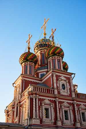 Close-up of the vibrant, ornate domes of Stroganov Church in Nizhny Novgorod, showcasing intricate Russian architecture with golden crosses against a clear blue skyの写真素材