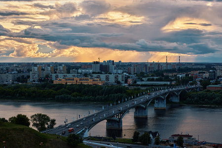 A stunning sunset Over Kanavinsky Bridge and Oka River in Nizhny Novgorod, casting golden rays through cloudsの写真素材