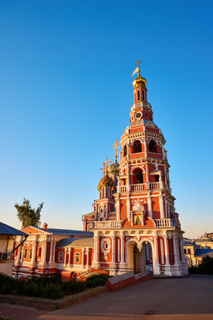 The vibrant Stroganov Church, also known as the Christmas Church, glows at dusk in Nizhny Novgorod, showcasing its ornate architecture and golden domes against a clear skyの写真素材