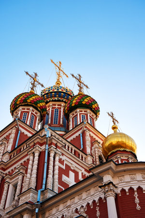 Close-up of the vibrant, ornate domes of Stroganov Church in Nizhny Novgorod, showcasing intricate Russian architecture with golden crosses against a clear blue skyの写真素材