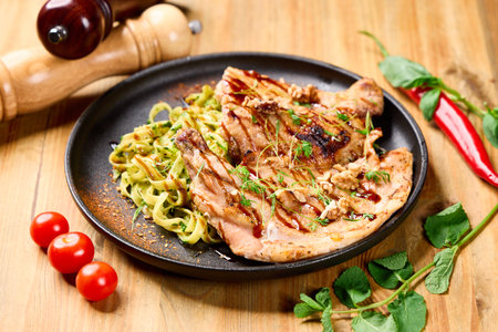 Juicy grilled chicken steak paired with aromatic herb pasta, cherry tomatoes, walnuts, and fresh herbsâan elegant, protein-rich plate perfect for upscale restaurant menusの写真素材