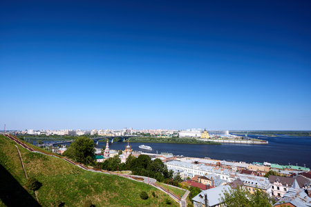 High-angle morning shot over Nizhny Novgorod capturing Christmas Church, Alexander Nevsky Cathedral, Kanavinsky Bridge and a tourist ship in soft golden dawn lightの写真素材