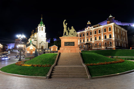 The Minin and Pozharsky Monument glows at night at the Kremlin base in Nizhny Novgorod, surrounded...