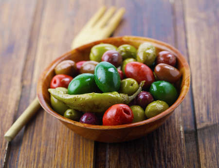 Assorted olives on a wooden tableの写真素材