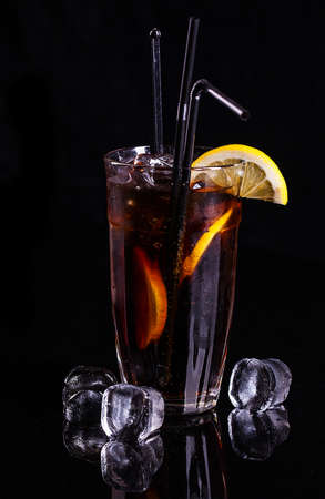 Glass of cola with ice and lemon on white.
