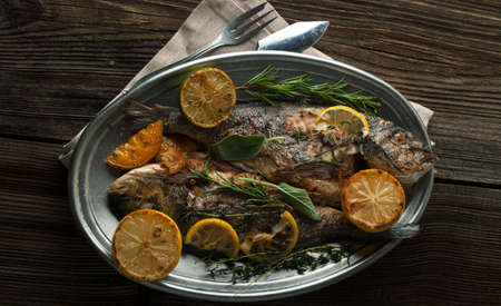 Grilled Dorada with a lemon and spices on a wooden backgroundの写真素材