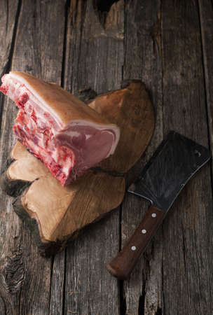Raw pork chop with spices, salt and garlic on a wooden backgroundの写真素材