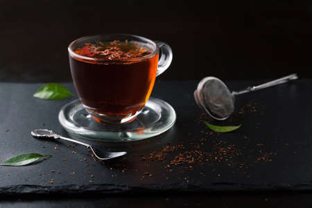 Cup of tea and tea leaves on a dark backgroundの写真素材