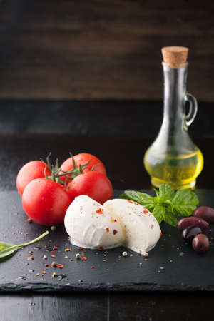 Caprese salad with mozzarella, fresh tomato and basil on a plateの写真素材