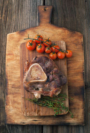 Osso buco roasted with thyme on a wooden backgroundの写真素材
