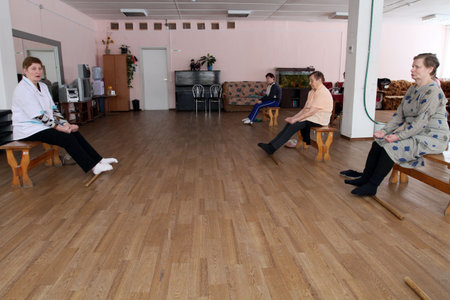 PODPOROZHYE, RUSSIA - MARCH 11: Day of Health in Center of social services for pensioners and the disabled Otrada (gymnastics with sticks for eldery), March 11, 2010 in Podporozhye, Russia.のeditorial素材