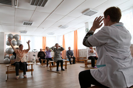 PODPOROZHYE, RUSSIA - MARCH 11: Day of Health in Center of social services for pensioners and the disabled Otrada (gymnastics with sticks for eldery), March 11, 2010 in Podporozhye, Russia.のeditorial素材