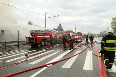 MOSCOW - APRIL 30: Firefighters extinguishing fire at the Viking floating restaurant on the Berezhkovskaya embankment, April 30, 2010 in Moscow, Russia.のeditorial素材