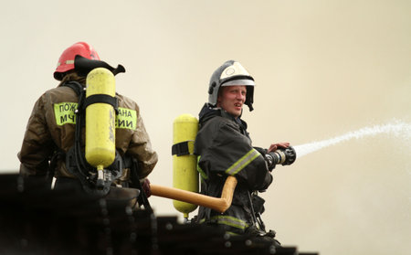 MOSCOW - APRIL 30: Firefighters extinguishing fire at the Viking floating restaurant on the Berezhkovskaya embankment, April 30, 2010 in Moscow, Russia.のeditorial素材