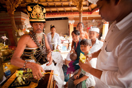 BALI, INDONESIA - MARCH 28: Hindu Brahmin during the ceremonies of Oton - is the first ceremony for baby's on which the infant is allowed to touch the ground on March 28, 2012 on Bali, Indonesia.のeditorial素材
