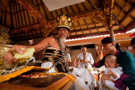 BALI, INDONESIA - MARCH 28: Unidentified child during the ceremonies of Oton - is the first ceremony for baby on which the infant is allowed to touch the ground on March 28, 2012 on Bali, Indonesia.のeditorial素材