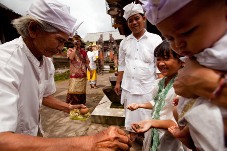 BALI, INDONESIA - MARCH 28: Unidentified child during the ceremonies of Oton - is the first ceremony for baby on which the infant is allowed to touch the ground on March 28, 2012 on Bali, Indonesia.のeditorial素材