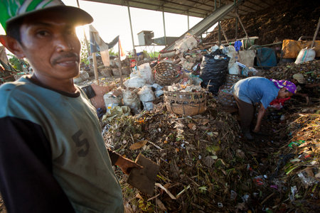 BALI, INDONESIA - APRIL 11: Poor people from Java island working in a scavenging at the dump on April 11, 2012 on Bali, Indonesia. Bali daily produced 10,000 cubic meters of waste.のeditorial素材