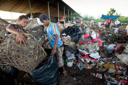 BALI, INDONESIA - APRIL 11: Poor people from Java island working in a scavenging at the dump on April 11, 2012 on Bali, Indonesia. Bali daily produced 10,000 cubic meters of waste.のeditorial素材