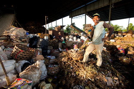 BALI, INDONESIA - APRIL 11: Poor people from Java island working in a scavenging at the dump on April 11, 2012 on Bali, Indonesia. Bali daily produced 10,000 cubic meters of waste.のeditorial素材