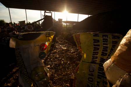 BALI, INDONESIA - APRIL 11: Poor people from Java island working in a scavenging at the dump on April 11, 2012 on Bali, Indonesia. Bali daily produced 10,000 cubic meters of waste.のeditorial素材