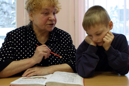 PODPOROZHYE, RUSSIA - JANUARY 31: Open Day at the Podporozhye Children House - unknown kid in the library read books with teacher, January 31, 2010 in Podporozhye, Russia.のeditorial素材