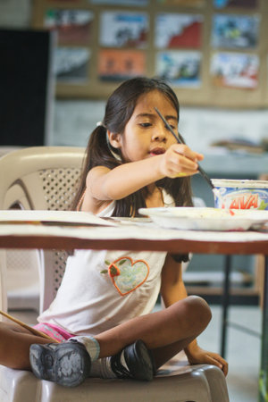 GUAYAQUIL, ECUADOR - FEBRUARY 8: Unknown kid in lesson drawing in primary school by project to help deprived children in deprived areas with education, February 8, 2011 in Guayaquil, Ecuador.のeditorial素材