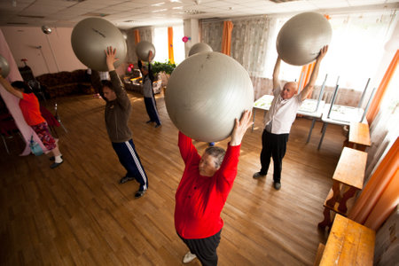 PODPOROZHYE, RUSSIA - JULY 5: Day of Health in Center of social services for pensioners and disabled Otrada (gymnastics with ball for eldery and disabled), July 5, 2012 in Podporozhye, Russia.のeditorial素材