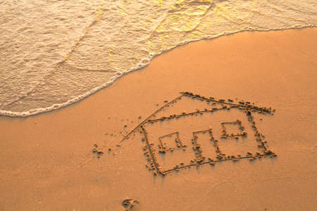 Conceptual photo  a house painted on beach sand の写真素材