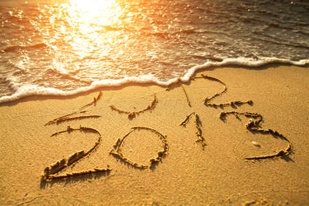 Conceptual photo  New Year 2013 is coming   - inscription 2012 and 2013 on a beach sand の写真素材