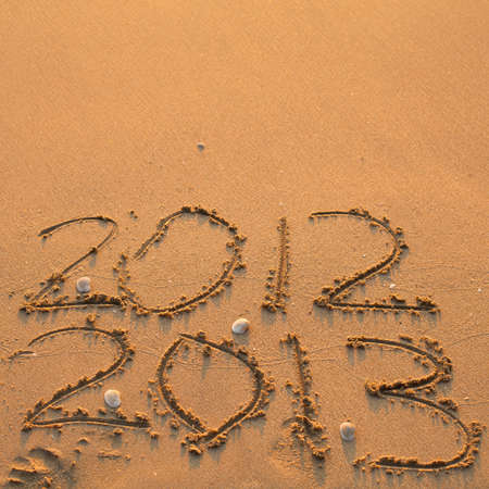 New Year 2013 is coming  - inscription 2012 and 2013 on a beach の写真素材