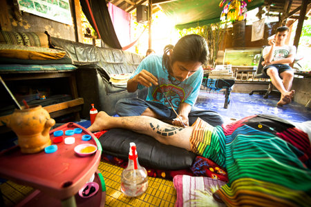 CHANG, THAILAND - DEC 24: Unidentified master makes traditional tattoo bamboo, Dec 24, 2012 in Chang, Thailand. Thai tattooists are very popular among tourists, prices range from 500 thai baht and up.のeditorial素材