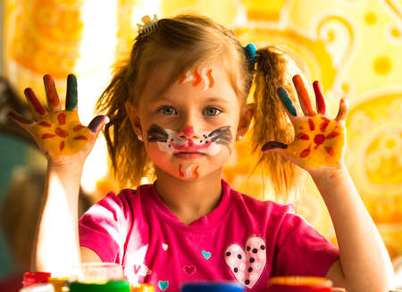 Beautiful little girl artist with paint of face