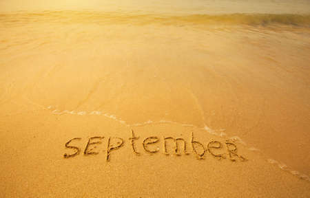 September - written in sand on beach texture - soft wave of the sea  months year series の写真素材