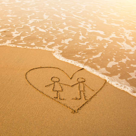 Shape of the pair inside heart of the sea on the beach in Valentine Day. Soft wave of the sea.の写真素材