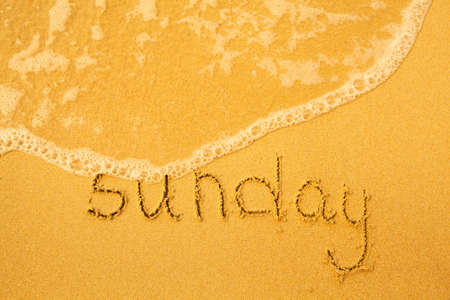 Sunday - written in sand on beach texture - soft wave of the sea  days week series 