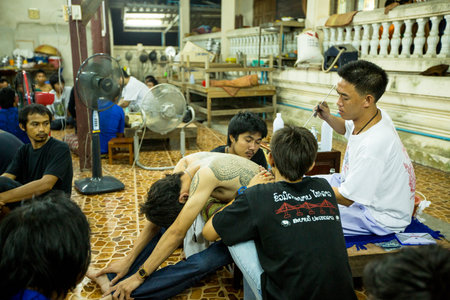 NAKHON CHAI, THAILAND - MAR 23: Unidentified monk makes traditional Yantra tattooing during Wai Kroo Master Day Ceremony in Wat Bang Pra on Mar 23, 2013 in Nakhon Chai, Thailand.のeditorial素材