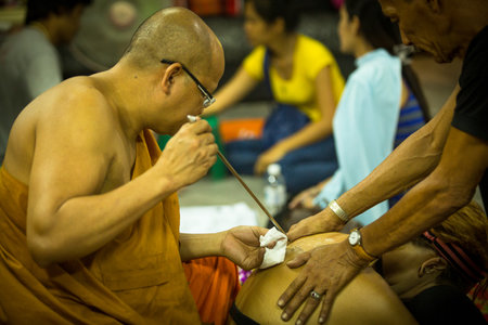 NAKHON CHAI, THAILAND - MAR 1: Unidentified monk makes traditional Yantra tattooing on Mar 1, 2012 in Nakhon Chai, Thailand. Yantra tattoo also called Sak Yant, practiced in Southeast Asian countries.のeditorial素材