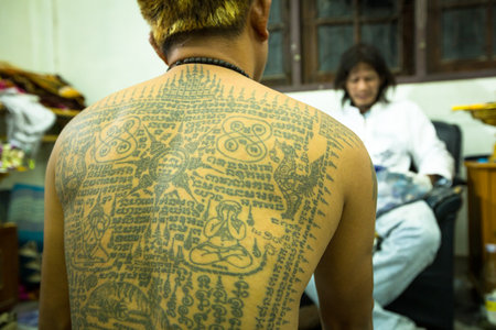 NAKHON CHAI, THAILAND - MAR 23: Unidentified monk makes traditional Yantra tattooing during Wai Kroo Master Day Ceremony in Wat Bang Pra on Mar 23, 2013 in Nakhon Chai, Thailand.のeditorial素材