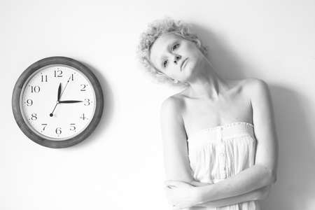 Conceptual portrait of girl with big clock, black and white photo.