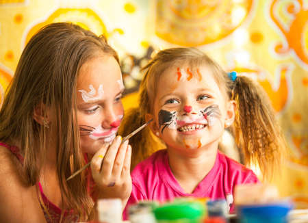 Funny little sisters playing with painting.の写真素材